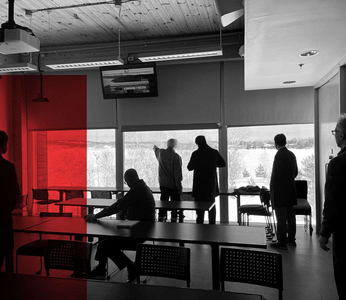 People looking out over an operation site from a meeting room window